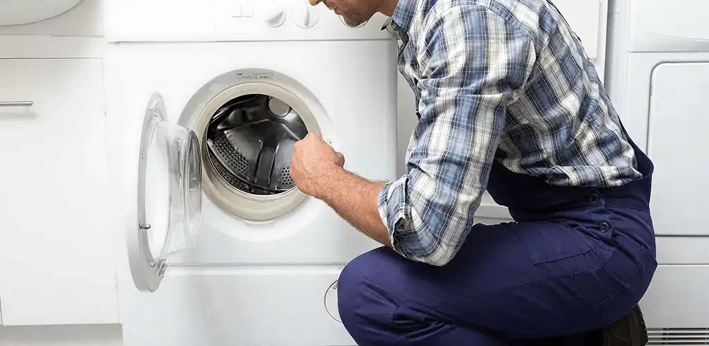 Handyman inspecting a dryer drum and internal parts for repair in Wilmington, NC