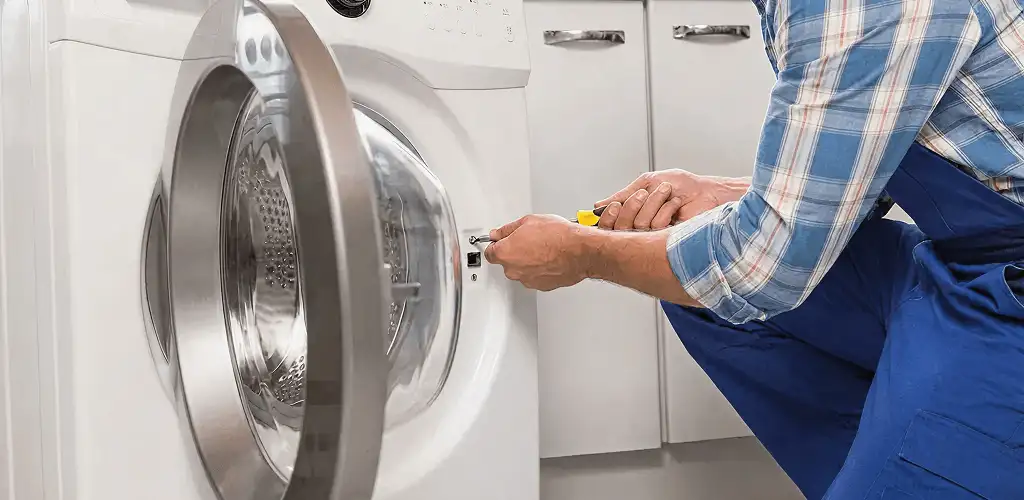 Handyman repairing a clothes dryer and checking electrical connections in Wilmington, NC