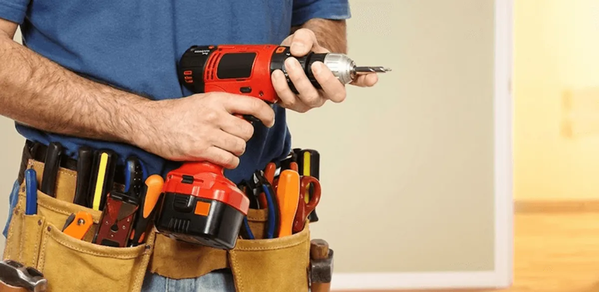 Handyman holding a power drill for home repairs and installations in Wilmington, NC
