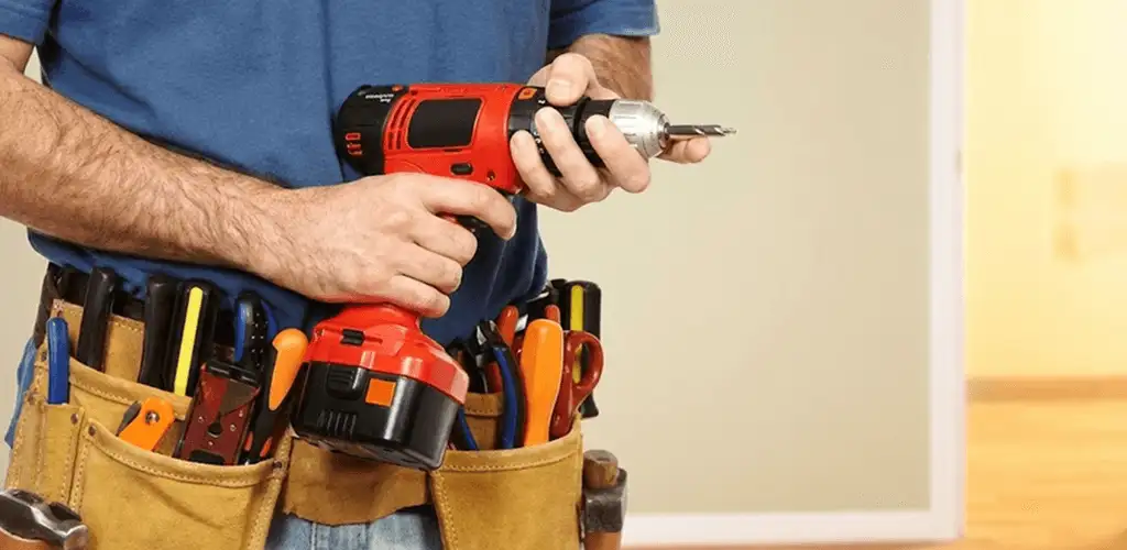 Handyman holding a power drill for home repairs and installations in Wilmington, NC
