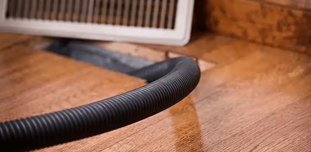 Air duct cleaning hose inserted into a floor vent for ductwork cleaning in Wilmington, NC